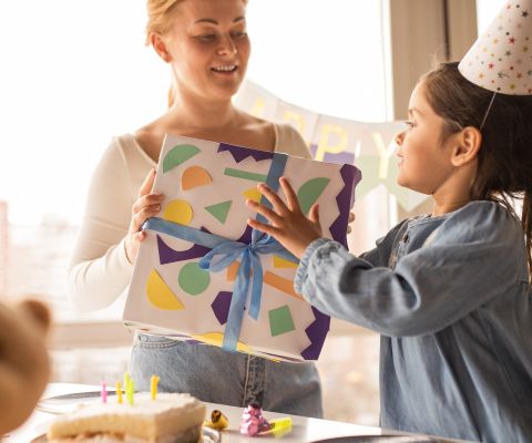 Una mamma dà un regalo di compleanno a una bambina
