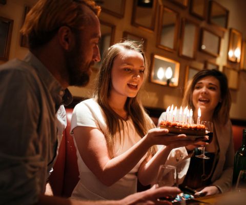 Ragazzina mentre soffia sulle candeline della torta di compleanno