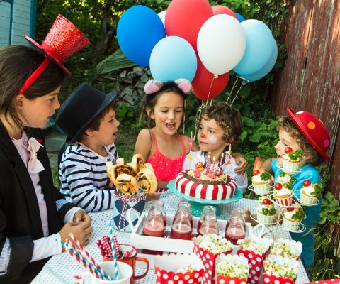Bambini che cantano buon compleanno davanti a un buffet dedicato al circo