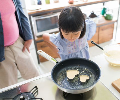 Bambina sta preparando pancake a forma di cuore
