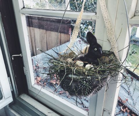 Lapin en chocolat dans un nid suspendu à la fenêtre