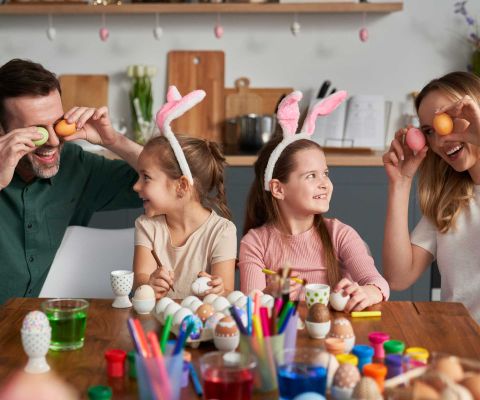 Famiglia che colora le uova per Pasqua