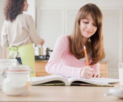 Schülerin in der Küche am Lernen