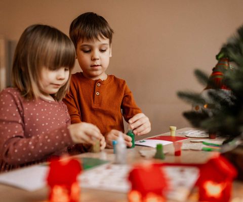 Zwei Geschwister basteln Weihnachtsgeschenke