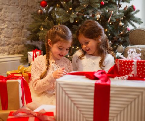 2 Mädchen beim Öffnen der Weihnachtsgeschenke