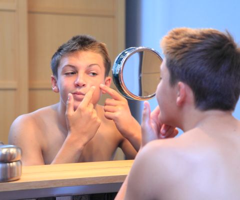 Junge betrachtet sich im Spiegel