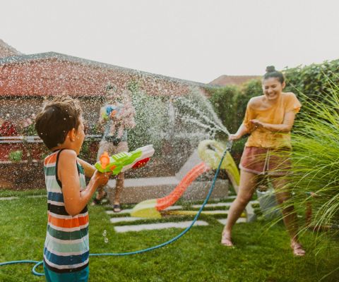 Una famiglia si diverte in giardino e gioca con l'acqua.