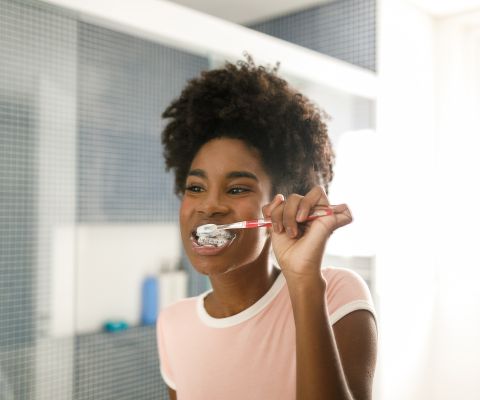 Une adolescente se brosse les dents