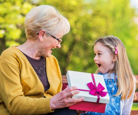 Grossmutter schenkt Mädchen ein Geschenk zum Schulanfang