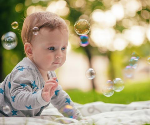 Bébé regardant des bulles de savon s’élever dans les airs