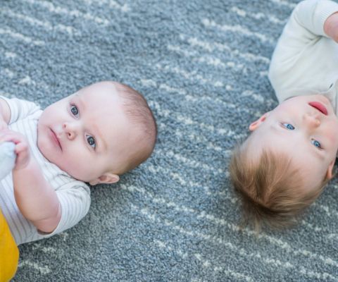 Deux bébés sur un tapis d’éveil