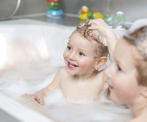 Due bambini si divertono nella vasca da bagno