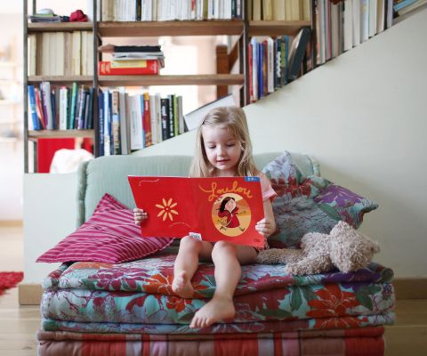 Un enfant lit un livre.