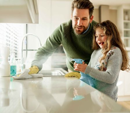 Vater und Tochter entfernen den hartnäckigen Kalk in der Küche
