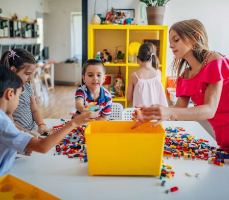 Kinder räumen LEGO Steine auf