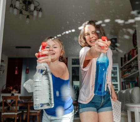 Deux jeunes filles joyeuses nettoient impeccablement les vitres