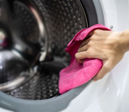 Eine Waschmaschine wird mit einem Tuch gereinigt