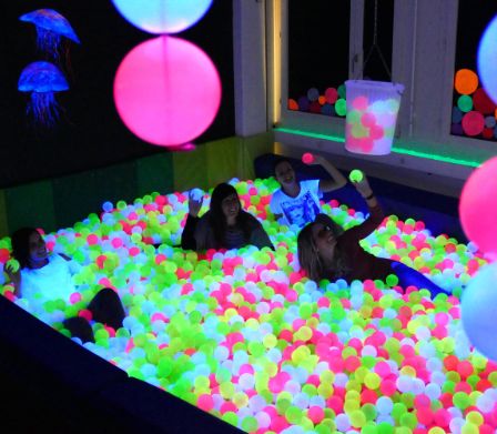 Bambini che giocano in una piscina di palline di colori sgargianti