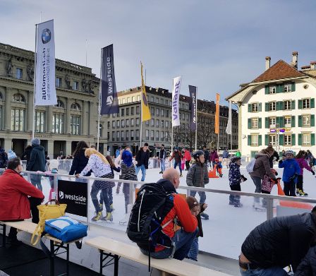 Pista di ghiaccio artificiale sulla Bundesplatz di Berna con gli storici palazzi sullo sfondo