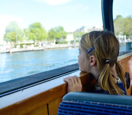 Une fillette regarde par la fenêtre d’un bateau de la Limmat
