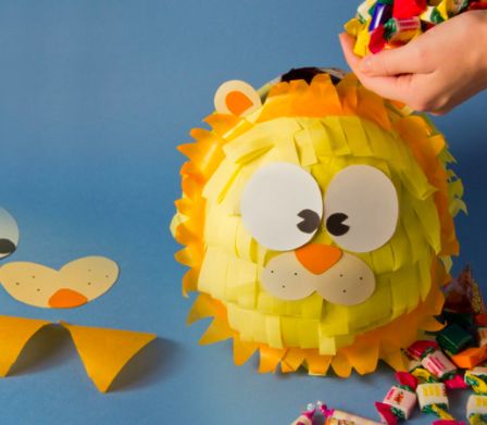 Ein Piñata-Löwe wird mit Süssigkeiten gefüllt.