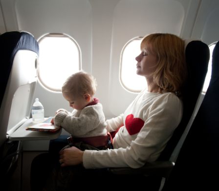 Frau mit Baby im Flugzeug