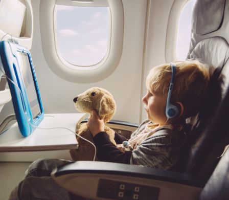 Un enfant avec une peluche dans un avion