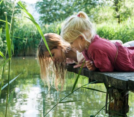 Mutter und Tochter am Tiere beobachten an einem Teich