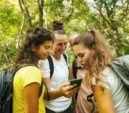 Eine Gruppe von jungen Frauen im Wald beim Geocaching
