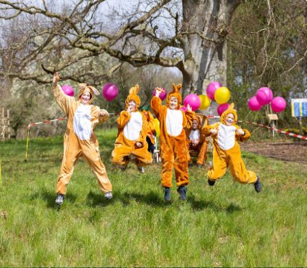 Vier Kinder in Osterhasen-Kostümen haben Spass bei der Ostereierjagd in Murten