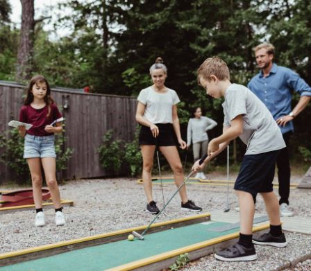 Familie spielt Minigolf