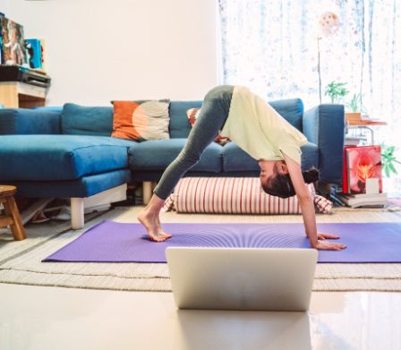 Una bambina pratica lo yoga in soggiorno