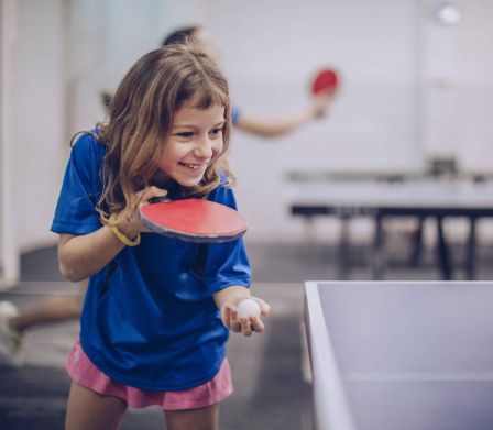 Bambina che si diverte giocando a ping-pong