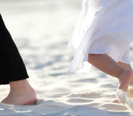 Bambino cammina a piedi nudi nella sabbia