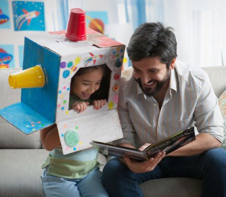 Vater und Tochter am Lesen und Spielen