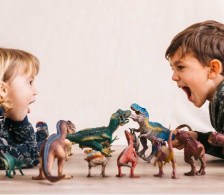 Kinder spielen mit Dinosauriern