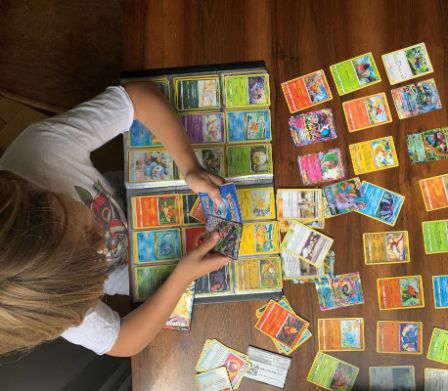 Bambino che colleziona carte Pokémon
