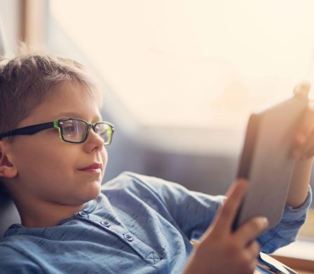 Un garçon lit un livre numérique