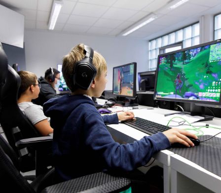Des enfants et des ados en train de jouer à des jeux vidéo à la Noetic Academy à Fribourg