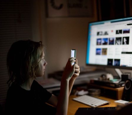 Temps en ligne des jeunes: un garçon avec un smartphone et un ordinateur