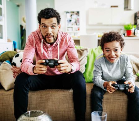 Console de jeux pour enfant: père et fils jouant ensemble à des jeux sur ordinateur