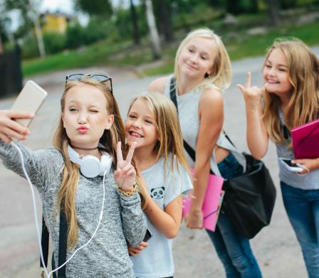 Vier Teenager-Mädchen drehen ein TikTok-Video