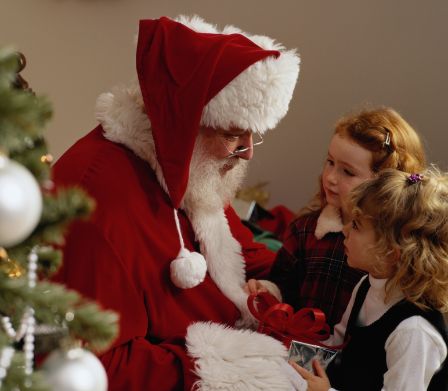 Babbo Natale che consegna un regalo a due bambine