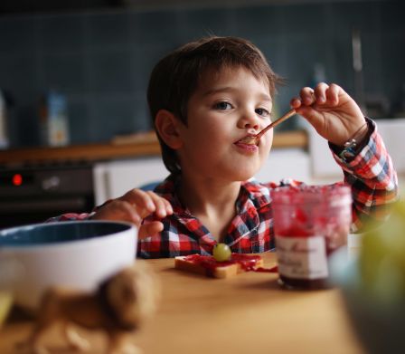 Boussole nutritionnelle chez les enfants: petit garçon mangeant des friandises avec gourmandise