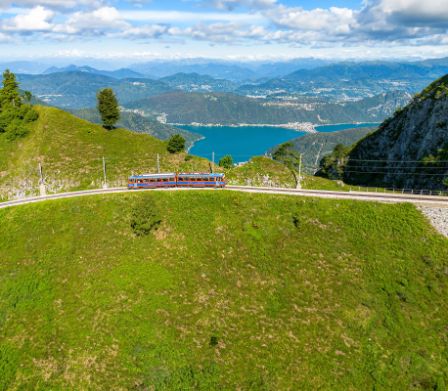 Die Zahnradbahn auf den Monte Generoso vor Alpen-Panorama und dem Luganersee