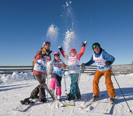 Eine Familie auf Ski im Schnee beim Migros Ski Day
