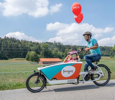 Vater fährt Famigros Cargo-Bike mit Kindern 