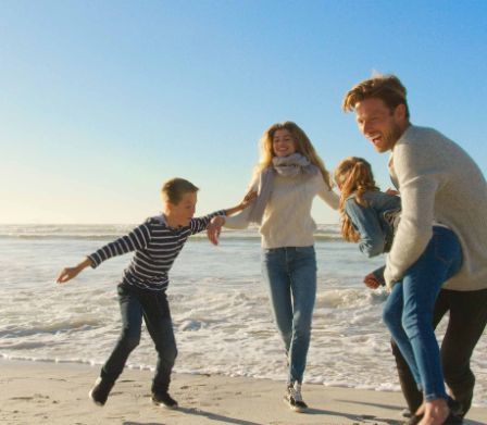 Une famille marche le long de la plage