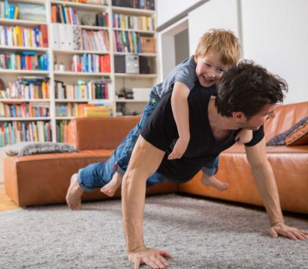 Vater trainiert mit Sohn im Wohnzimmer