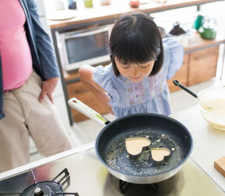 Bambina sta preparando pancake a forma di cuore